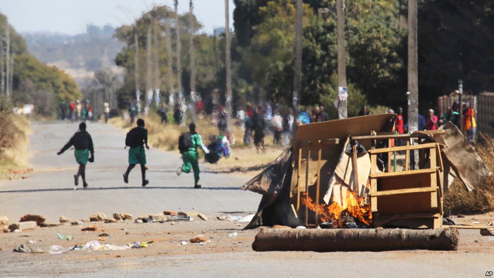 FILE: School children run past a burning barricade, following a job boycott called via social media platforms, in Harare, July,6, 2016 / Photo Credit: VOA Zimbabwe