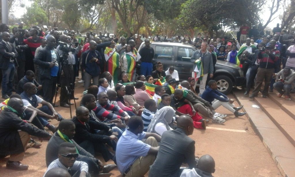 11:44 Emotional moments as people sit in front of the court and start singing / Photo Credit: NewsDay