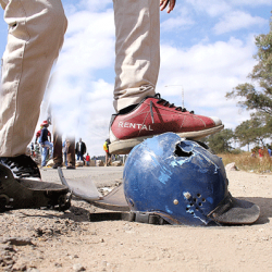 A protester steps on a riot police officer‘s helmet in Epworth, just outside Harare, minutes after demonstrators attacked the officer and disrobed him. The officer was later rushed to hospital by an ambulance.